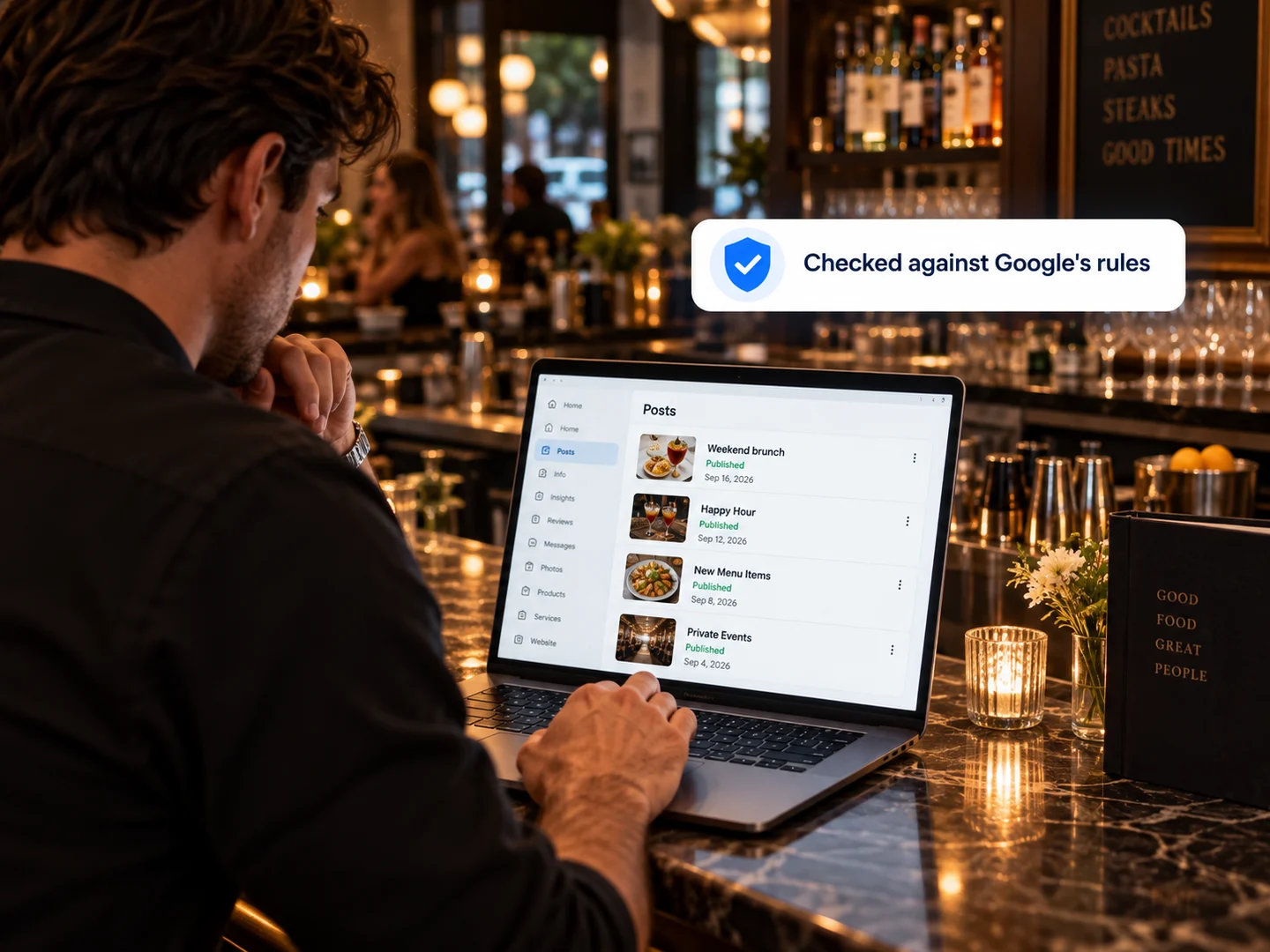 An owner at the bar reviewing published Google posts on a laptop, each checked against Google’s rules