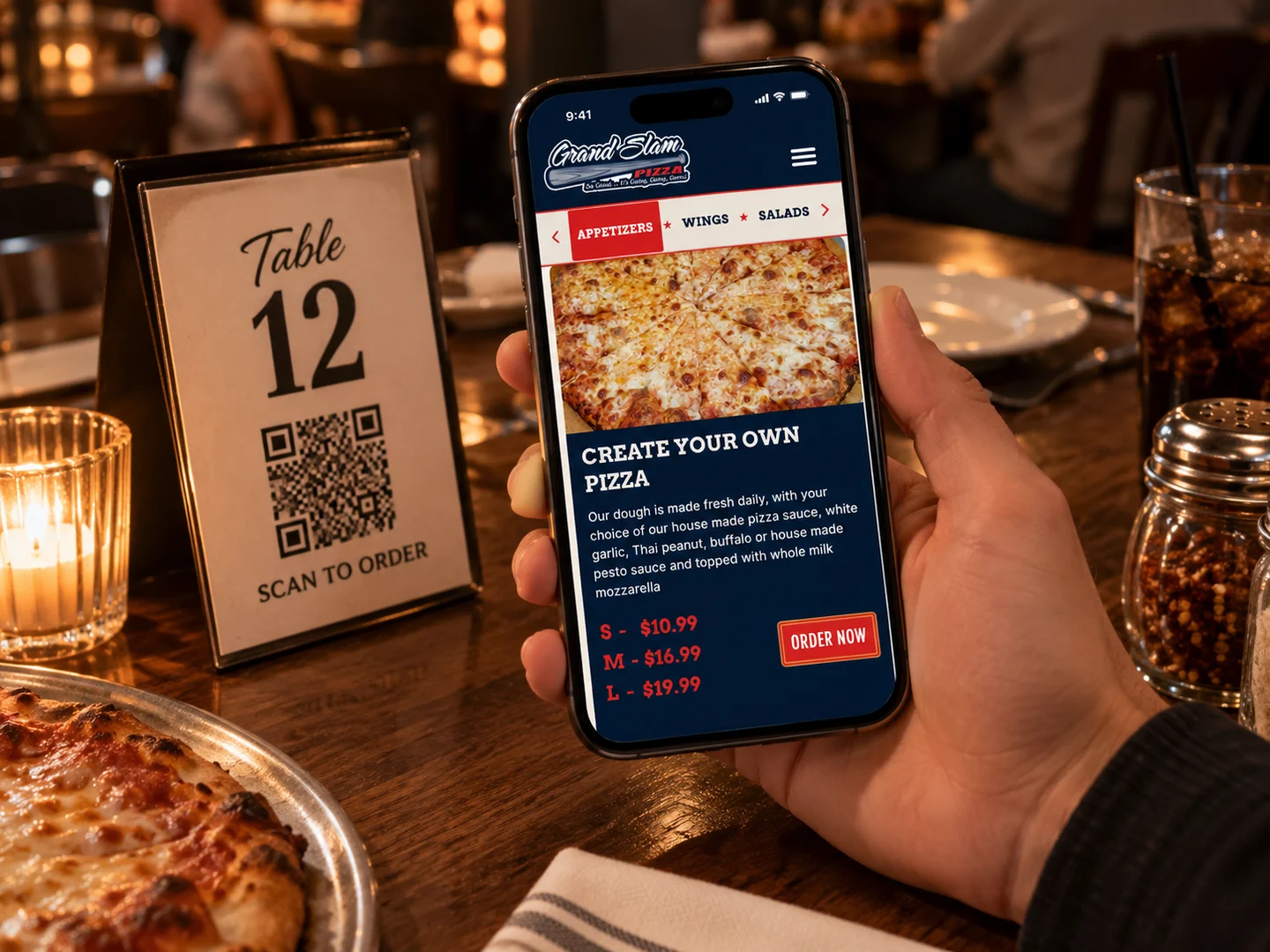 A guest at a table holding their phone over a Table 12 QR code, ordering from the restaurant’s menu